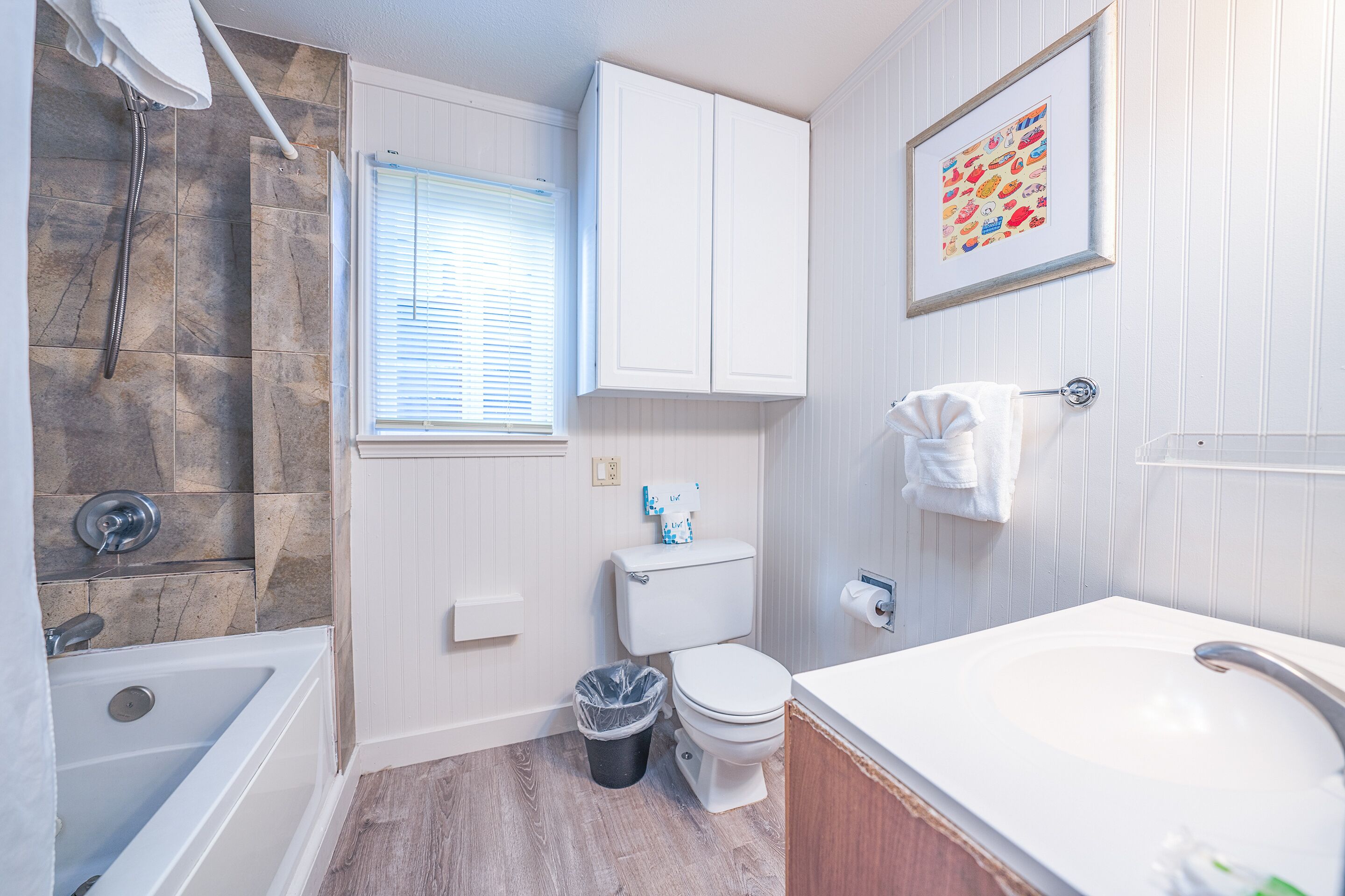 A bathroom with a bathtub, toilet, and sink.
