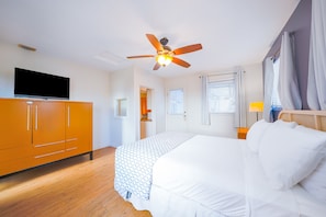 Relax in a spacious room with a large bed, flat-screen TV, and ceiling fan.