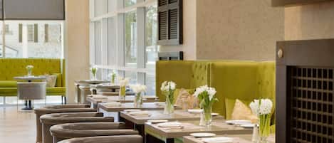 A restaurant with multiple tables, each set with white flowers and napkins.