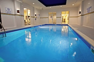 Una piscina interior con señalización clara que indica prohibido bucear y nadar bajo su propia responsabilidad.