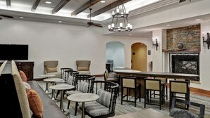 Un hall de hotel con zona de estar, bar y chimenea.