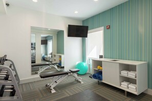 A gym with exercise equipment, a mirror, a television, and a shelf with towels. - Holiday Inn Express Hotel & Suites Vestal by IHG (Vestal)