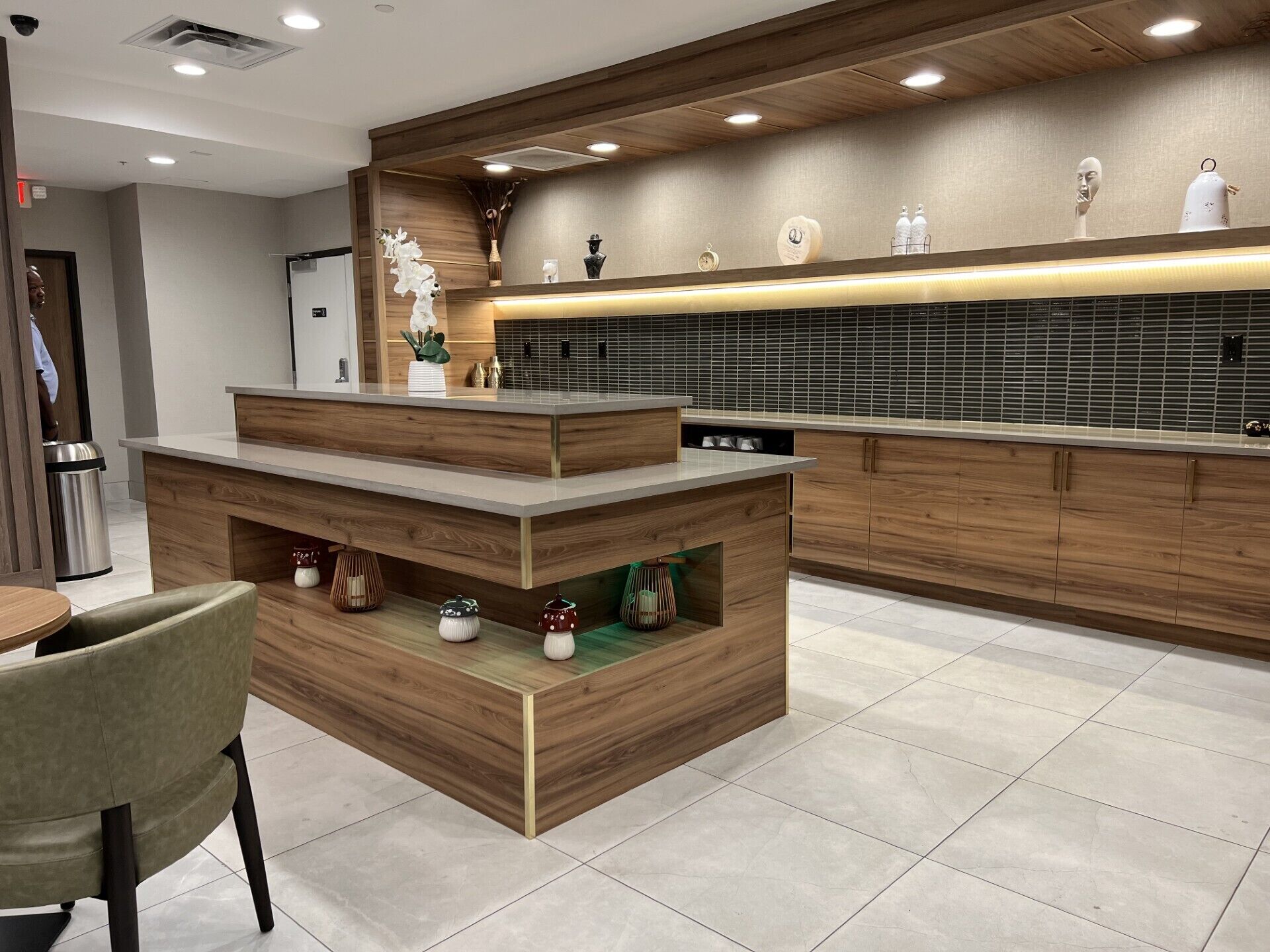 A modern kitchen with wooden cabinetry, a central island, and a tiled backsplash.