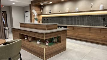 A modern kitchen with wooden cabinetry, a central island, and a tiled backsplash.