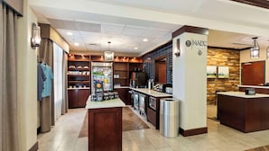 A hotel lobby with a reception desk, a minibar, a seating area, and a clothing rack. - DoubleTree by Hilton Front Royal Blue Ridge Shadows (Front Royal)