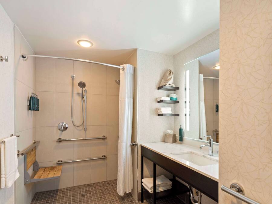 Un baño moderno con ducha, lavabo y espejo.