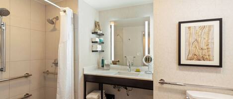 A modern bathroom with a shower, toilet, and sink.