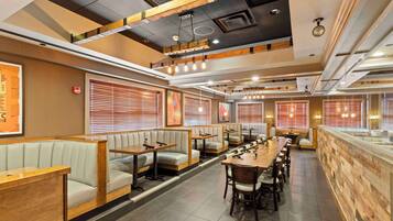 A restaurant with booths, tables, and a bar area.