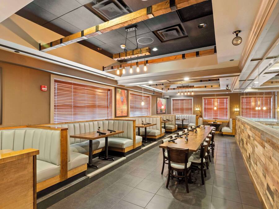 A restaurant with booths, tables, and a bar area.