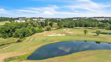 Golfers can enjoy a round on the scenic course surrounded by lush greenery and a serene pond.