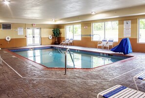 Una piscina interior con normas claras, un puesto de salvavidas y una zona de estar cubierta.