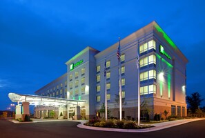 Een Holiday Inn hotel met een modern design, met een overdekte ingang en meerdere verdiepingen.