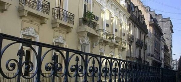 A row of multi-story buildings with ornate balconies and wrought iron railings.