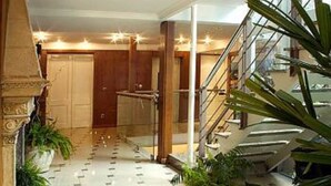 Un hall d’entrée spacieux, doté d’un sol carrelé, d’un escalier et de plantes en pot.