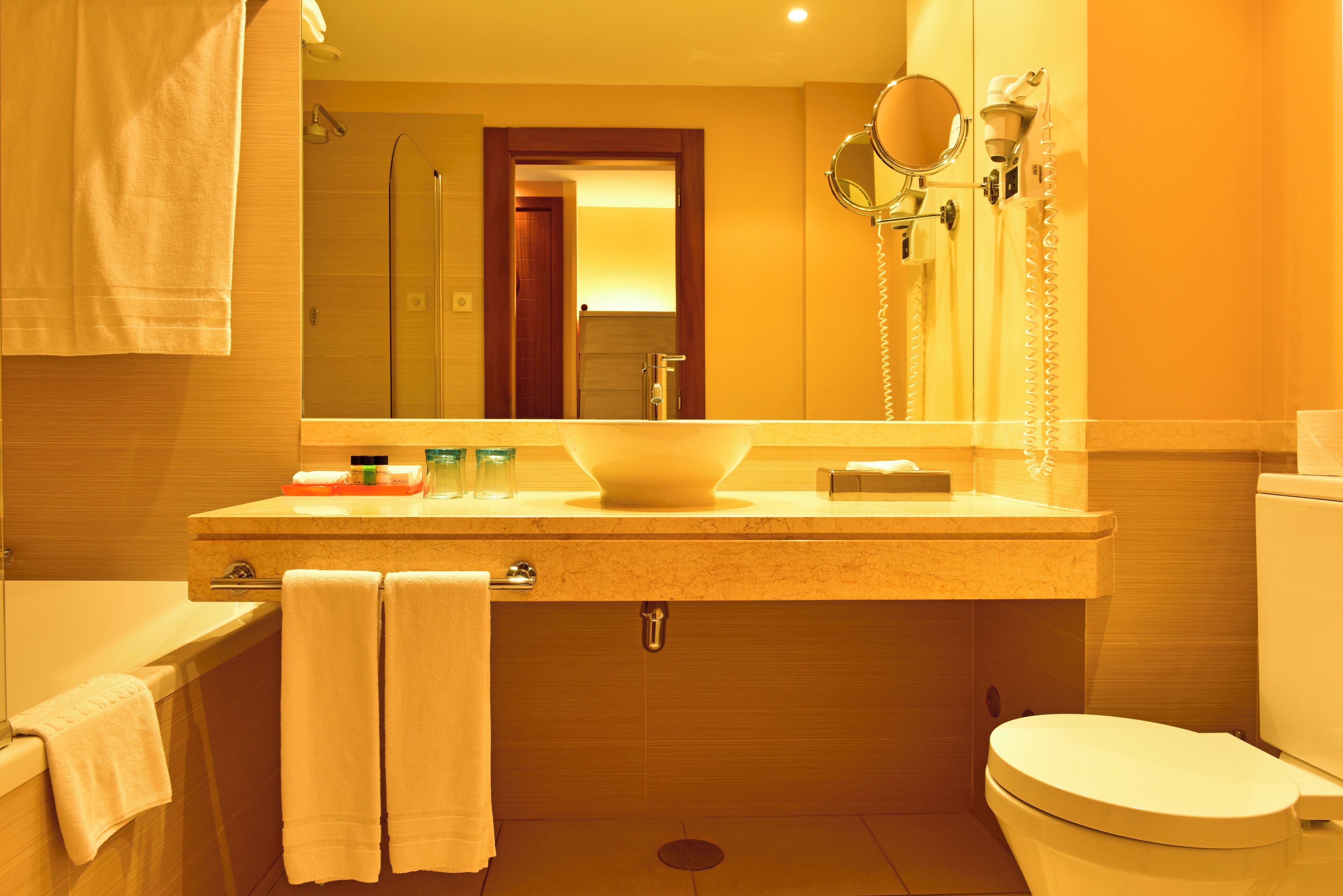 A bathroom with a sink, mirror, and toilet.
