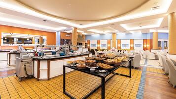 En buffetopstilling med diverse madvarer og en serveringsvogn.