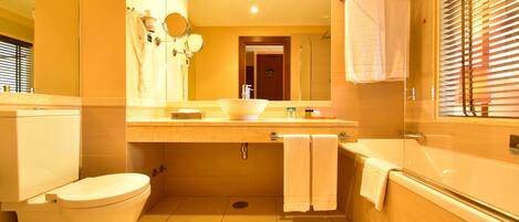 Un bagno con WC, lavandino e vasca da bagno. Sopra il lavandino c'è uno specchio e sopra la vasca da bagno un porta asciugamani.