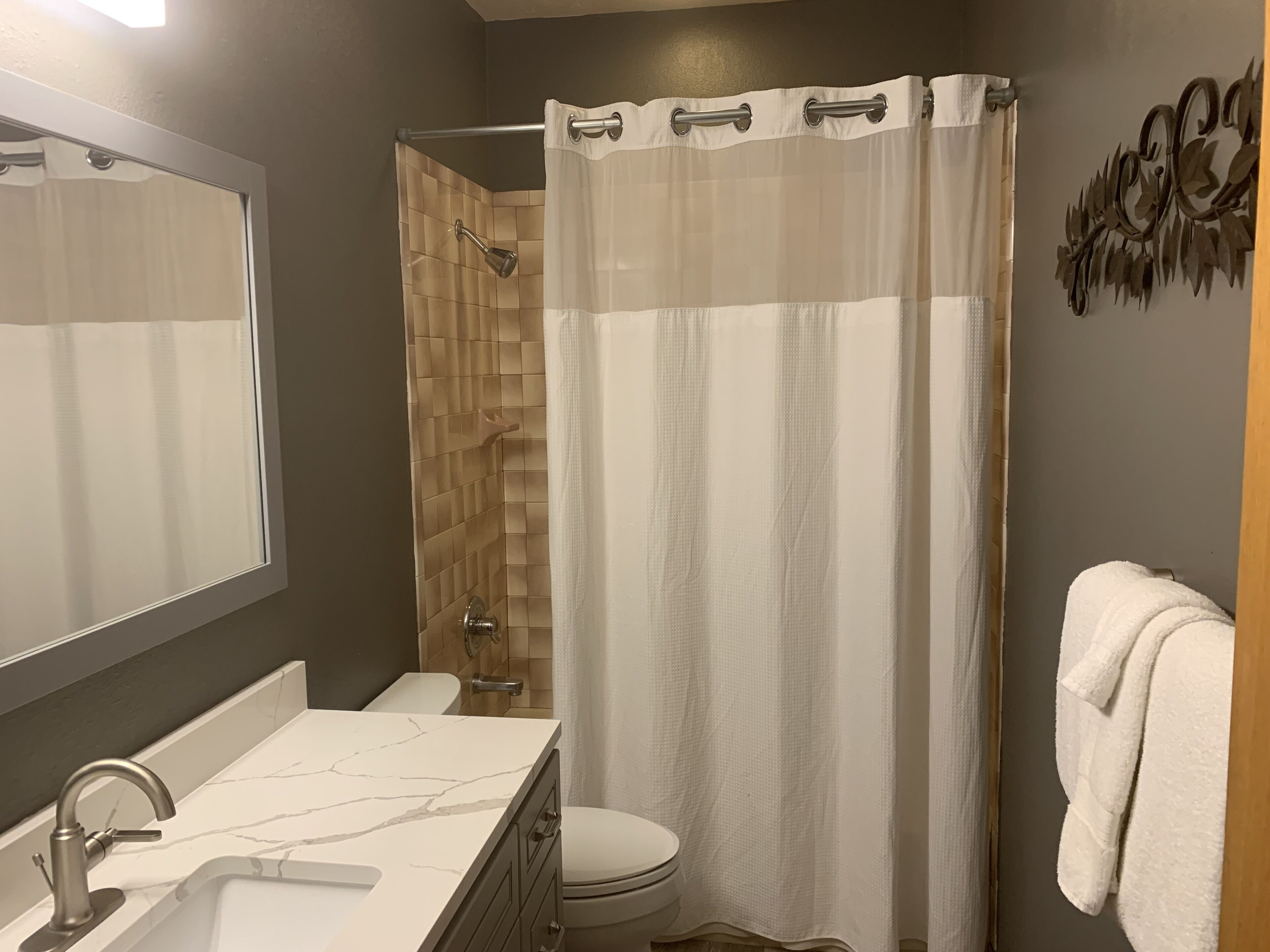 Un baño con ducha, inodoro y lavamanos.