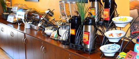 Ein reichhaltiges Buffet mit verschiedenen Speisebehältern, Kaffeemaschinen und Beilagen.