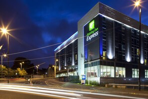 Experience the sleek, modern design of this urban hotel, featuring a prominent glass facade and clear signage.