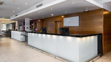 Et moderne receptionsområde med skranke, et ur og et skilt for Holiday Inn Express.