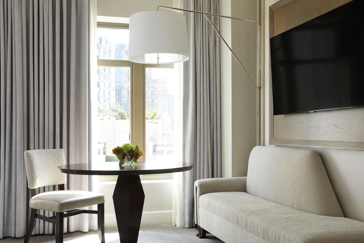 A modern living room with a round table, a sofa, and a chair.
