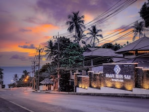 Baah Hin Sai Resort & Spa features a traditional architectural design surrounded by lush tropical vegetation and palm trees.