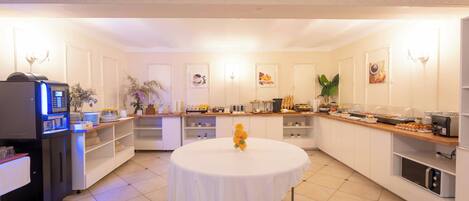 Una cocina amplia con una isla central, equipada con refrigerador, microondas y cafetera.