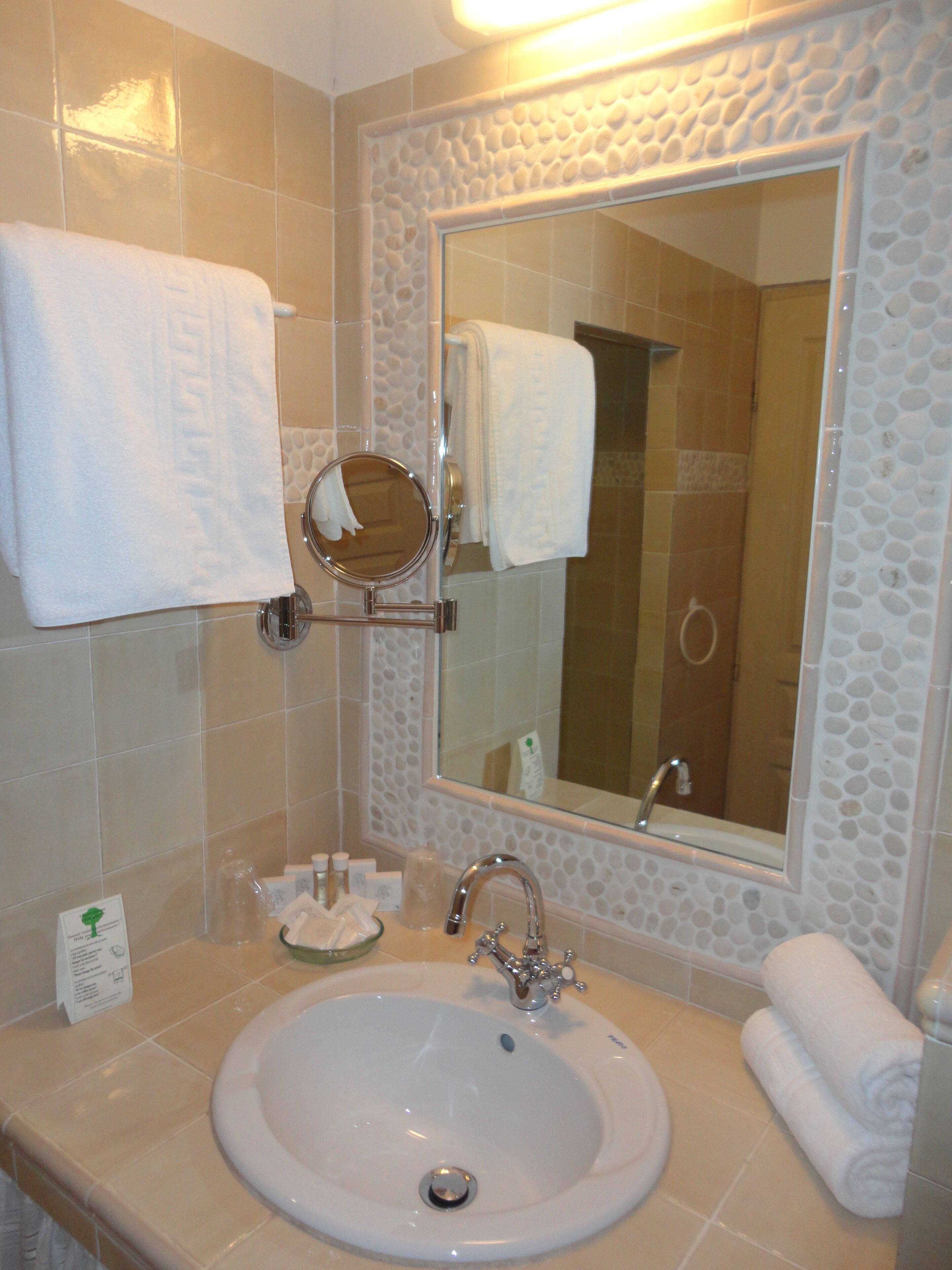 Ein Badezimmer mit Waschbecken, Spiegel und Handtuchhalter.