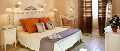 Un dormitorio con cama, mesitas de noche, cómoda y espejo.