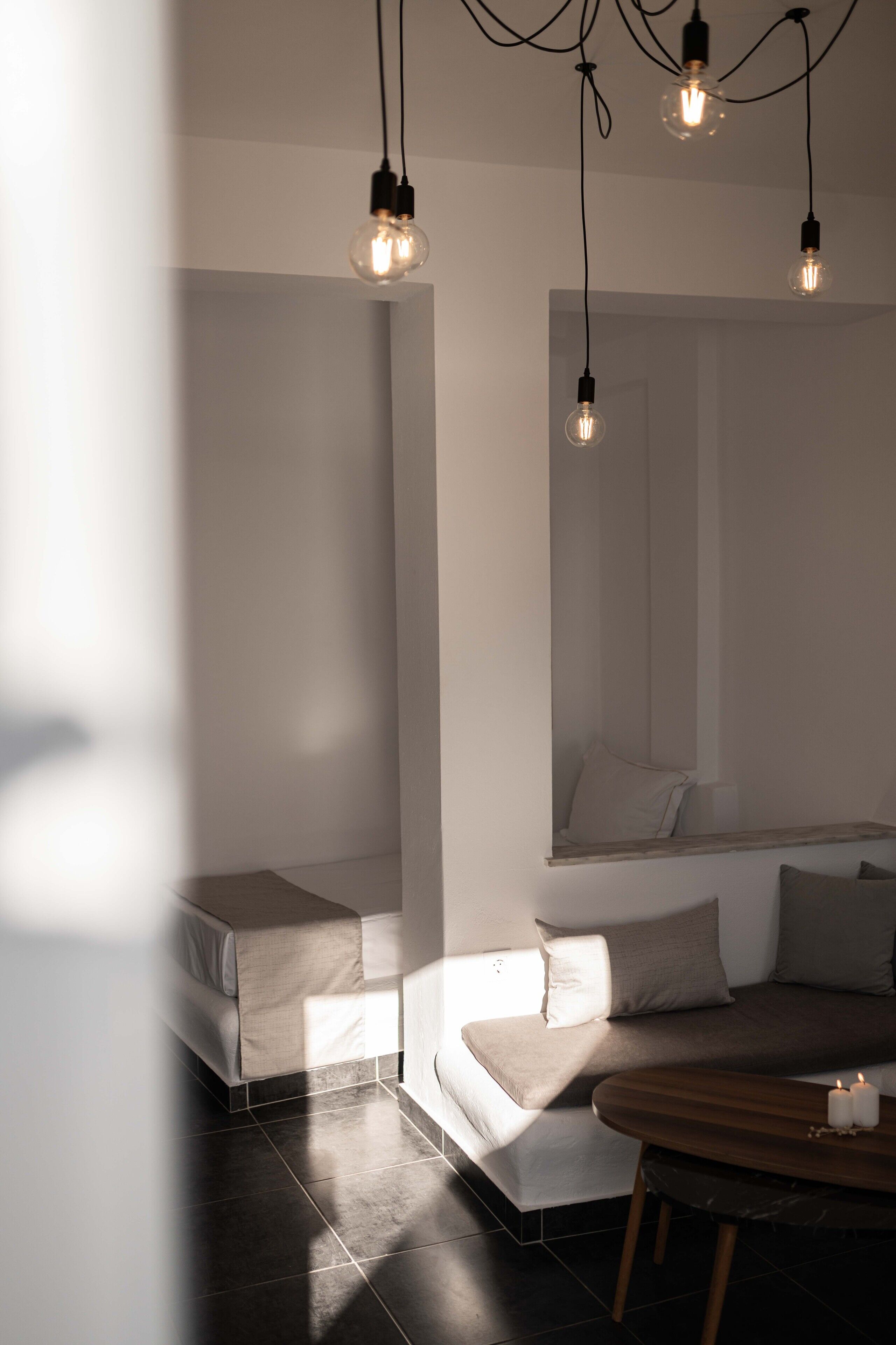 Une chambre moderne avec un lit, un banc et une table décorée de bougies.