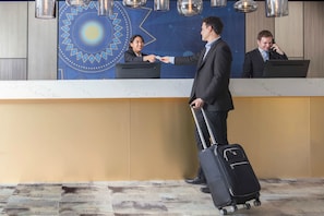 A reception desk with a modern design, a check-in counter, and a digital display. - Metro Aspire Hotel, Sydney (Ultimo)
