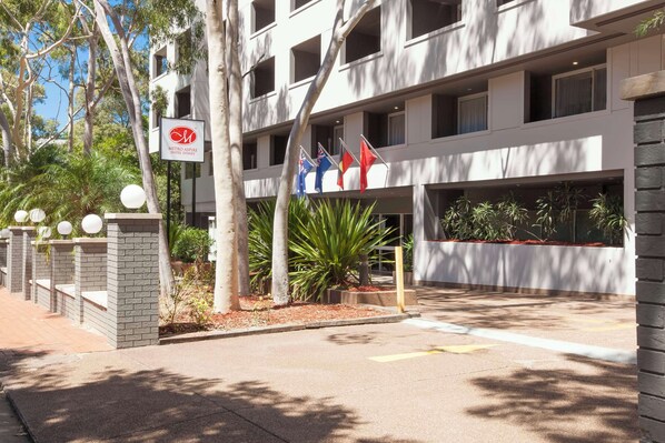 A modern hotel building with a sign for Metro Aspire Hotel Sydney.