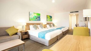 A hotel room with a large bed, a sofa, a table, and two paintings on the wall. - Metro Aspire Hotel, Sydney (Ultimo)