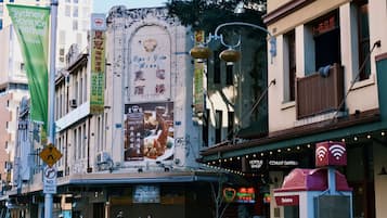 A street with various buildings, including a hotel named 'COVENT GARDEN HOTEL' and a restaurant named 'EMERSON'S GARDEN'. There are also signs for 'Sydney Science Festival' and 'Telstra'.