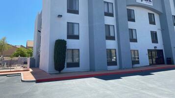 A modern hotel building with a flat facade, multiple windows, and a sign reading "spark by Hilton".
