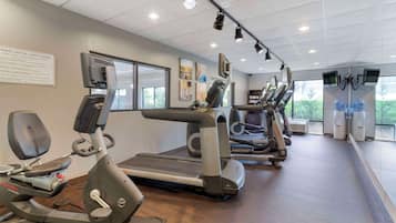 A gym with treadmills, stationary bikes, and an elliptical machine.