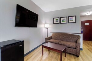 A living room with a flat-screen TV, a sofa, a coffee table, and framed pictures on the wall.