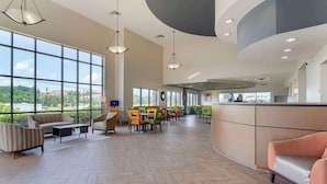 A spacious lobby with large windows, a reception desk, and multiple seating areas. - Comfort Suites Kodak Sevierville (Kodak)