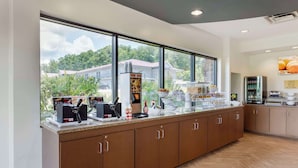 A modern kitchen with a large window, a coffee machine, and a refrigerator. - Comfort Suites Kodak Sevierville (Kodak)
