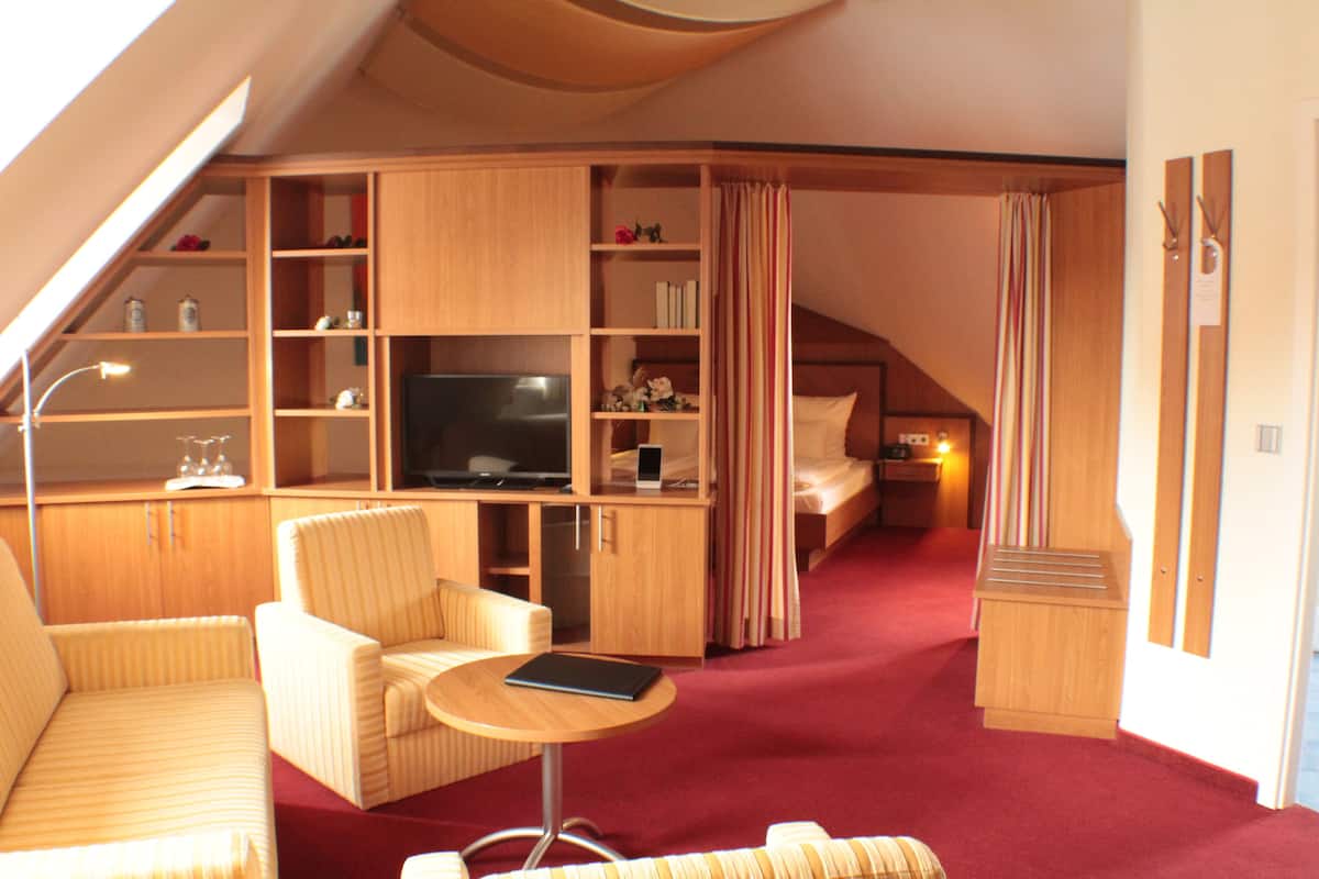 Una habitación compacta y bien iluminada, con televisión, zona de estar y armarios.