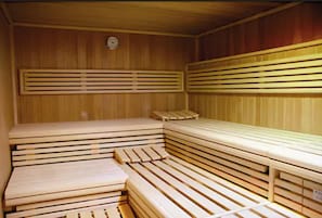 Una sauna con bancos de madera y paredes de listones.