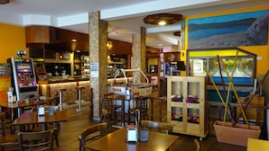 Un restaurante con muebles de madera, mesa de fútbol de mesa y zona de bar.