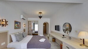 A modern bedroom with a bed, bedside table, and a vanity with a mirror and lamp. - Sami Beach Hotel (Bodrum)