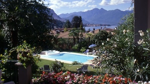 Zona de piscina con sillones de descanso y vistas a las montañas.