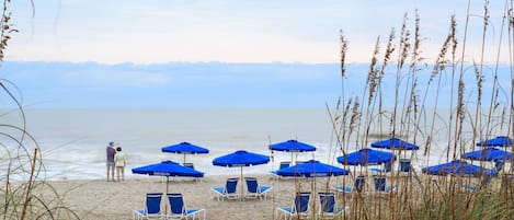 En la playa, sillas reclinables de playa, sombrillas, pesca