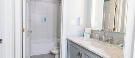 A bathroom with a shower, toilet, and sink.