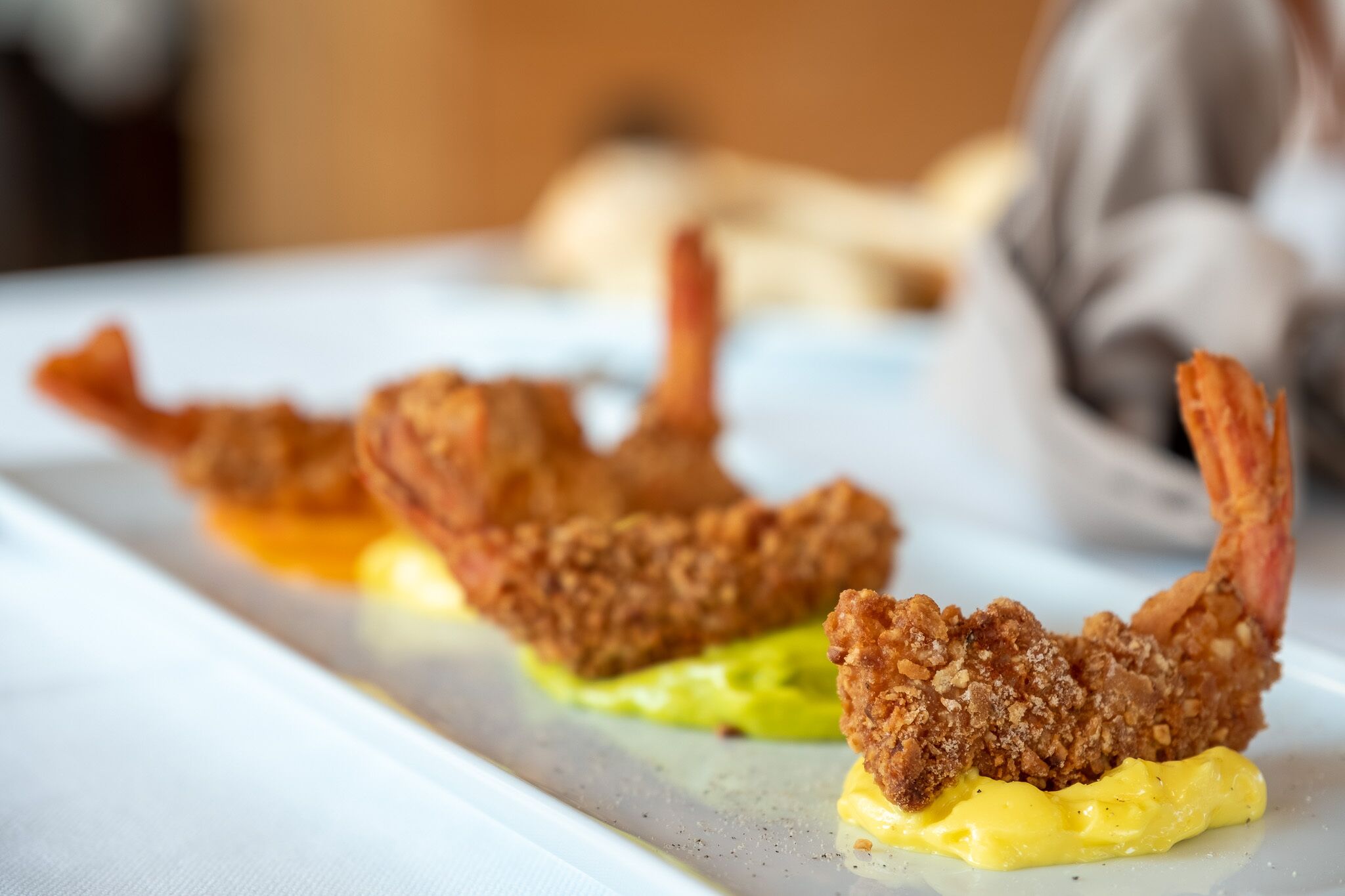 A plate with fried food items and a yellow sauce.
