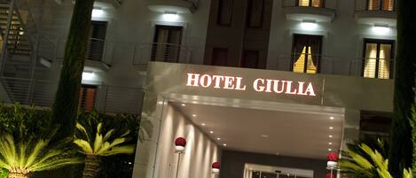 Hotel Giulia with illuminated steps and a signboard.