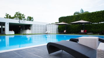 Una piscina al aire libre de temporada, sombrillas